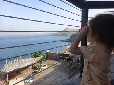a little girl looking out at the ocean at Casa Fabrice in Ribeira da Prata