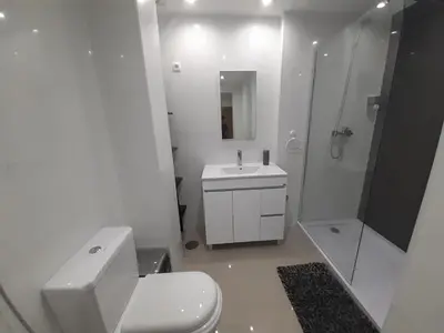 a white bathroom with a toilet and a shower at Apto T1 Sweet Home in Praia
