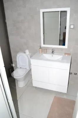 a bathroom with a white sink and a toilet at AG TOUR LDA - Apartamentos Turísticos in Praia