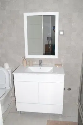 a bathroom with a white sink and a mirror at AG TOUR LDA - Apartamentos Turísticos in Praia