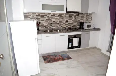 a white kitchen with a sink and a microwave at AG TOUR LDA - Apartamentos Turísticos in Praia