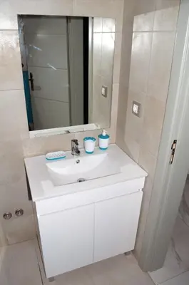 a bathroom with a white sink and a mirror at AG TOUR LDA - Apartamentos Turísticos in Praia