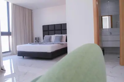 a bedroom with a large bed and a large window at Hotel Por Do Sol in Tarrafal