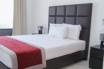 a bedroom with a large bed with a black headboard at Hotel Por Do Sol in Tarrafal