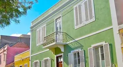 a green and white building with a balcony at Casa Colonial in Mindelo
