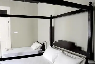 a bedroom with two beds with white sheets at Casa Colonial in Mindelo