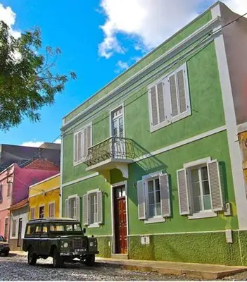 a jeep parked in front of a green building at Casa Colonial in Mindelo