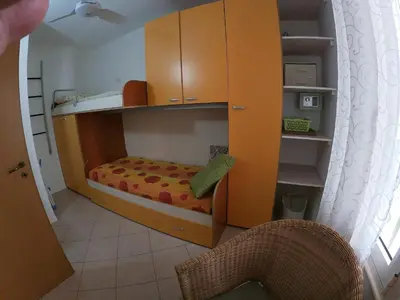 a small childs bedroom with a bunk bed and cabinets at Ibiscus in Santa Maria