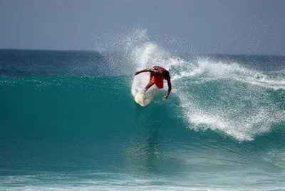a man riding a wave on a surfboard in the ocean at Ibiscus in Santa Maria
