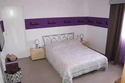 a bedroom with a bed with a purple headboard at LAFAYETTE Alojamentos in Espargos