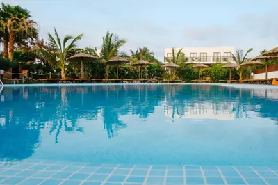 a swimming pool at a resort with palm trees and umbrellas at Melia Dunas Beach Resort & Spa - All Inclusive in Santa Maria