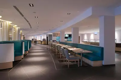 a dining room with tables and blue seats in a restaurant at Melia Dunas Beach Resort & Spa - All Inclusive in Santa Maria