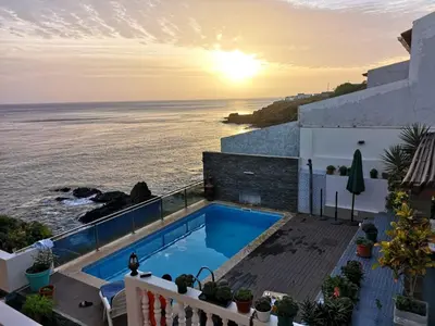 a view of the ocean from a house with a swimming pool at Cactus Guest House in Cidade Velha