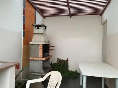 a white chair sitting in front of a outdoor oven at Cactus Guest House in Cidade Velha