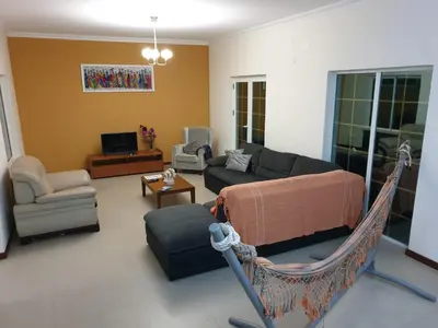 a living room with a couch and a hammock at Cactus Guest House in Cidade Velha