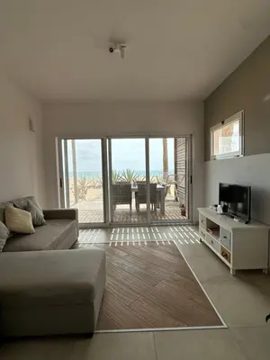 a living room with a couch and a television at Villa Cristina Alojamento, Praia de Chaves, Boa Vista, Cape Verde, WI-FI in Sal Rei