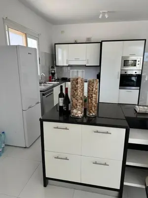 a kitchen with white appliances and a black counter top at Villa Cristina Alojamento, Praia de Chaves, Boa Vista, Cape Verde, WI-FI in Sal Rei