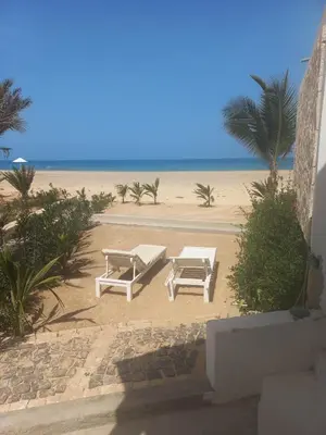 two picnic tables and a bench on the beach at Villa Cristina Alojamento, Praia de Chaves, Boa Vista, Cape Verde, WI-FI in Sal Rei