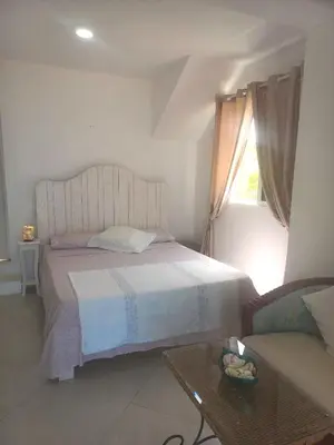 a bedroom with a bed and a window and a table at Villa Cristina Alojamento, Praia de Chaves, Boa Vista, Cape Verde, WI-FI in Sal Rei