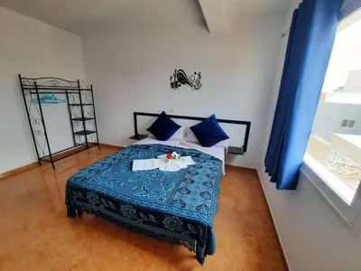 a bedroom with a bed with blue sheets and blue pillows at FRANMAY APARTMENTS - 7 modern apartments near the beach & city in Santa Maria