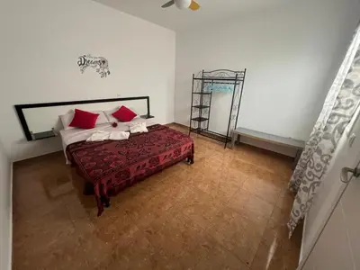 a bedroom with a bed with red and white pillows at FRANMAY APARTMENTS - 7 modern apartments near the beach & city in Santa Maria