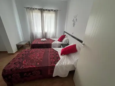 a bedroom with two beds with red pillows at FRANMAY APARTMENTS - 7 modern apartments near the beach & city in Santa Maria