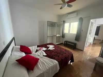 a bedroom with a bed with red and white pillows at FRANMAY APARTMENTS - 7 modern apartments near the beach & city in Santa Maria