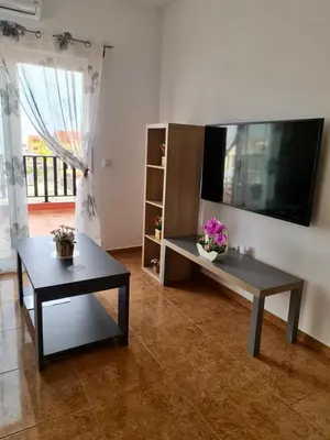 a living room with two tables and a flat screen tv at FRANMAY APARTMENTS - 7 modern apartments near the beach & city in Santa Maria