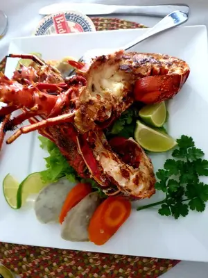 a plate of food with lobster and vegetables on a table at Txon DFogo Pensão Restaurante in São Filipe
