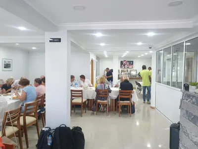 a group of people sitting at tables in a restaurant at Txon DFogo Pensão Restaurante in São Filipe