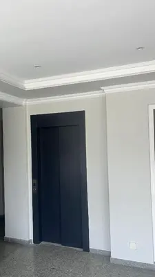 a black door in the middle of a white wall at Txon DFogo Pensão Restaurante in São Filipe