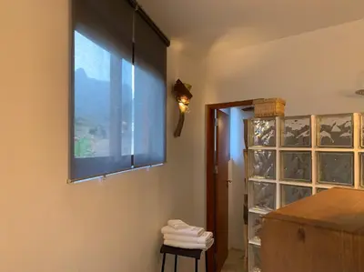 a window in a room with a shelf of wine bottles at Palmeira Da Cruz EcoLodge in Chã da Igreja