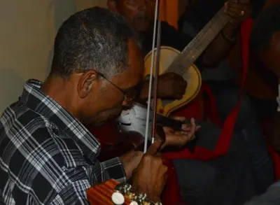 a man playing an instrument with a violin at Residensia Ka Denxu in Vila Nova Sintra