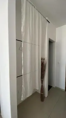 a room with a white curtain and a vase at Maison Residencial casa de ferias in Pedra Badejo