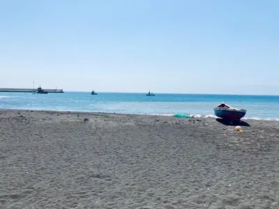 a boat sitting on a beach with the ocean at Pedra de Rala in Porto Novo