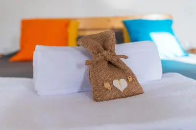 a small bag on a bed with white pillows at Apartamento Zinha Amwilla Guesthouse in Mindelo