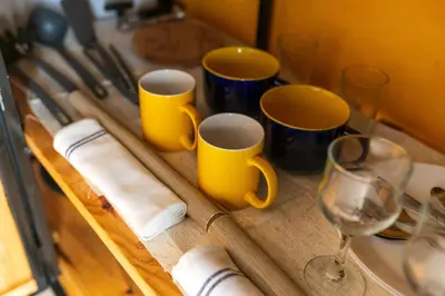 a table with two yellow cups and a wine glass at Apartamento Zinha Amwilla Guesthouse in Mindelo