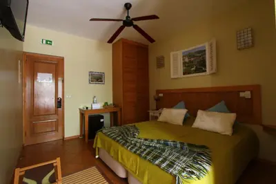 a bedroom with a bed and a ceiling fan at Kira's Boutique Hotel in Mindelo