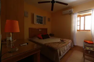 a bedroom with a bed and a ceiling fan at Kira's Boutique Hotel in Mindelo