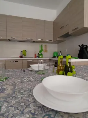 a kitchen with a table with a white plate and glasses at Rosa dei Venti Apartment 50meter beach front in Sal Rei