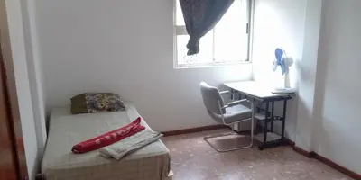 a small room with a bed and a desk and a window at Cubico Tota in Praia