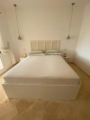 a large white bed in a bedroom with two lamps at Villa Nº 25 Alfredo Marchetti Suites on the Beach,Praia de Chaves BV in Cabeçadas