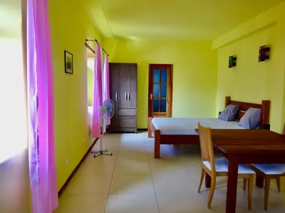 a bedroom with a bed and a table and a dining room at Apartment with sea view near the beach and the village center! in Tarrafal
