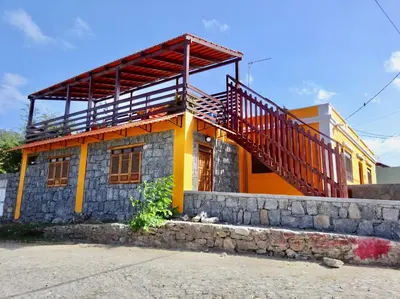 a house with a staircase on top of it at Apartment with sea view near the beach and the village center! in Tarrafal