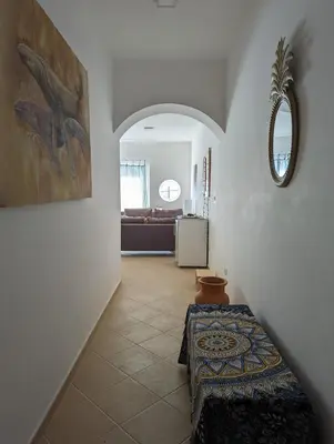 a hallway with a room with a table and a mirror at African Sunset in Sal Rei