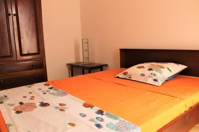 a bed with an orange sheet and a pillow on it at African Sunset in Sal Rei