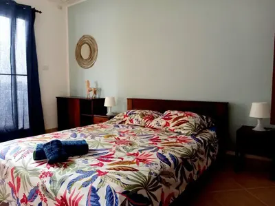 a bedroom with a bed with a floral comforter at African Sunset in Sal Rei