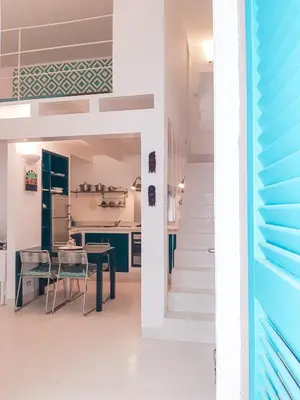 a kitchen and dining room with a table and a staircase at App Rosanna, Estoril Beach, 2steps from the sea, Free Wi-Fi & AC in Sal Rei