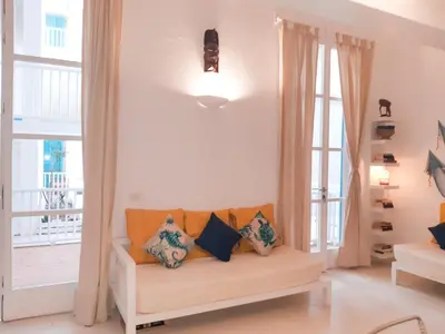 a living room with a couch with pillows at App Rosanna, Estoril Beach, 2steps from the sea, Free Wi-Fi & AC in Sal Rei