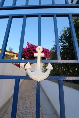 a wooden anchor hanging from a building with a window at L' Ancora - Room With Exclusive Pool And Terrace in Palmeira